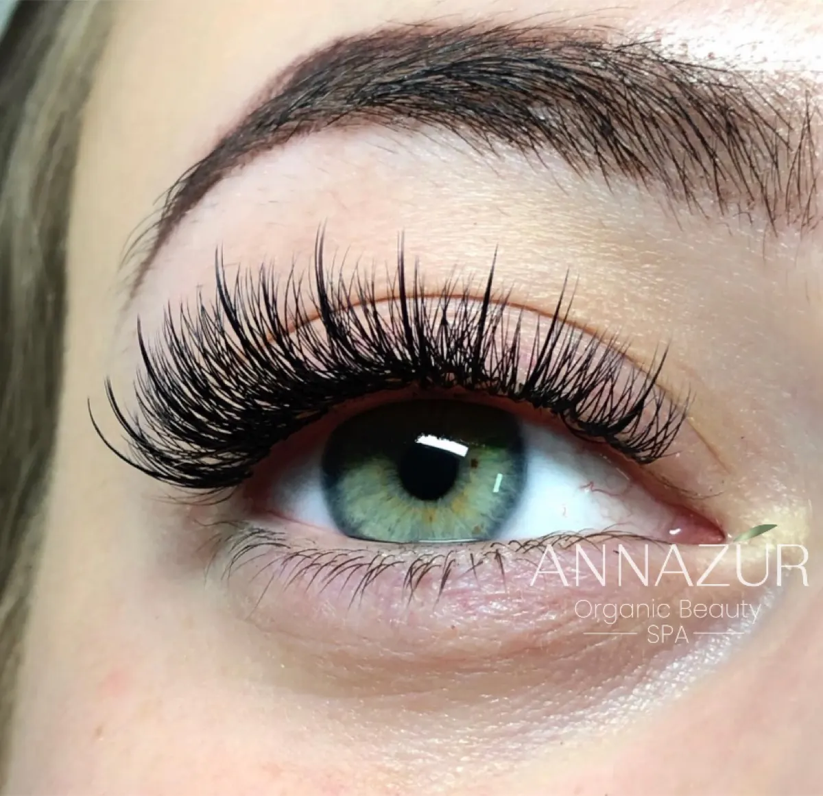 Close-up of full eyelash extensions on a green eye