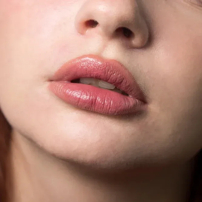 Client shows swollen lips during initial healing stage after professional permanent makeup tattooing