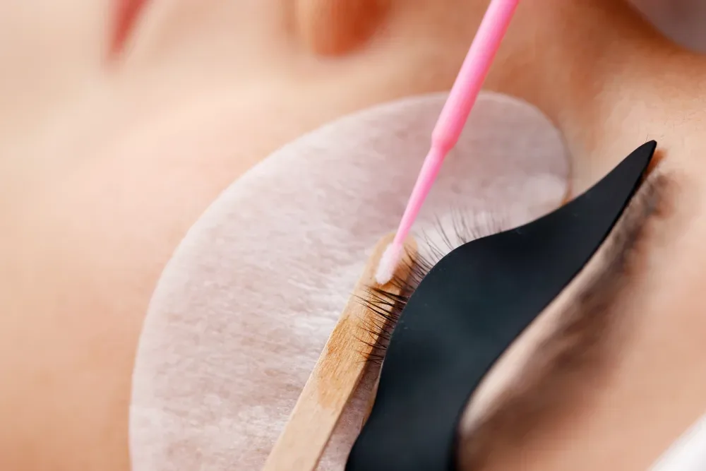 An unsafe DIY lash removal attempt using improper tools, illustrating the risk of serious damage to natural lashes.