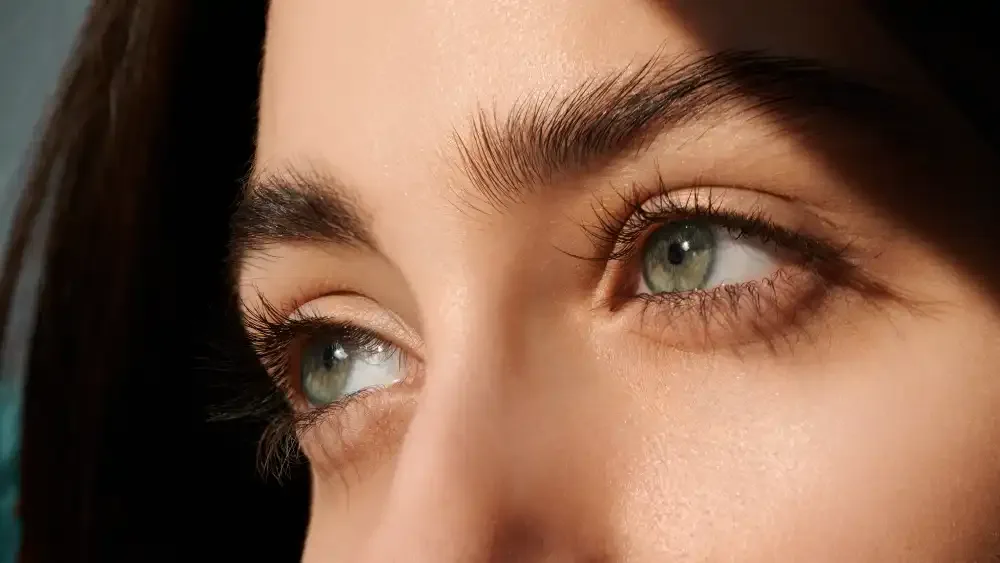 A close-up of a woman's eyes with beautiful extensions, representing the "natural luxury" look achievable with safe makeup practices.