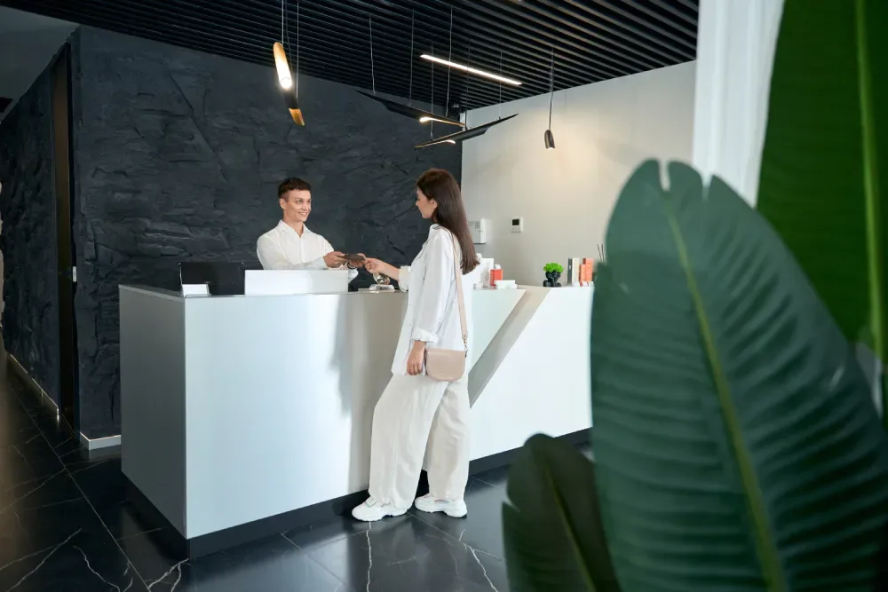 A client at the reception desk of a modern salon, illustrating a clean and professional environment for lash services.