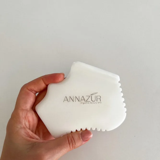 ANNAZUR branded gua sha tool held in hand