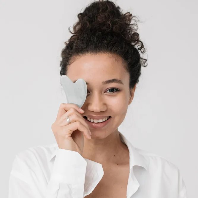 Gua sha tool used during a facial treatment