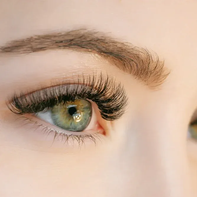 Model wearing photogenic volume lash extensions with wet eyelashes effect, creating stunning professional camera look